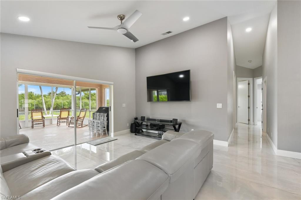 Living area with ceiling fan, recessed lighting, and a high ceiling
