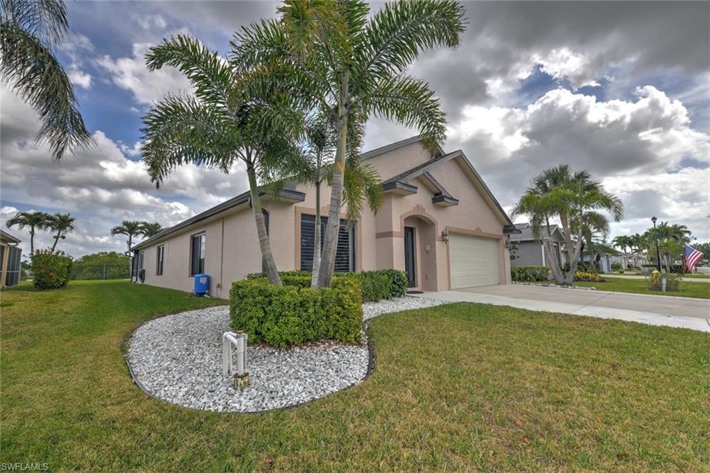 View of front of home with a front yard, stucco siding, driveway, and an attached garage