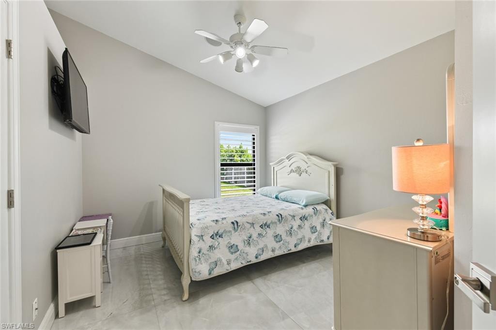 Bedroom featuring vaulted ceiling, finished concrete floors, ceiling fan, and arched walkways