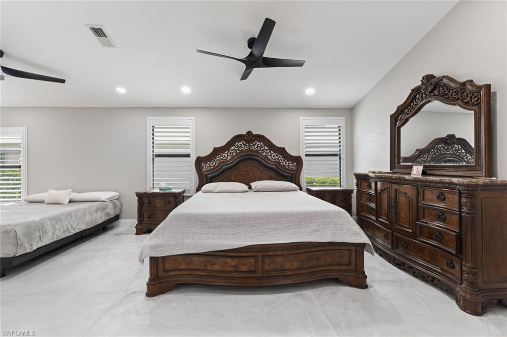 Bedroom with a ceiling fan, multiple windows, and recessed lighting