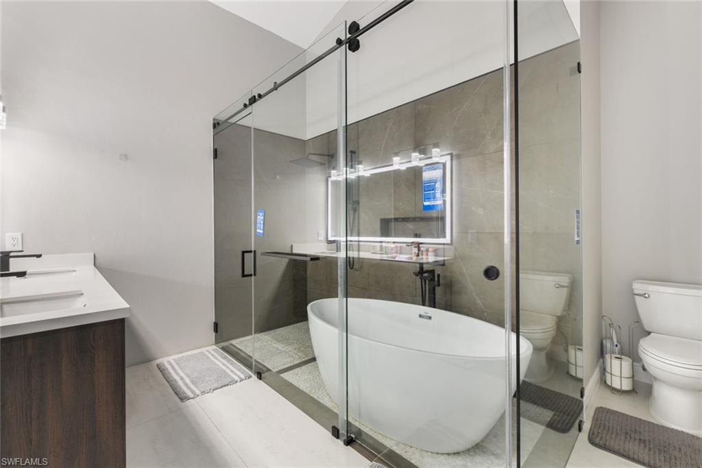 Full bath with a shower stall, a soaking tub, and double vanity