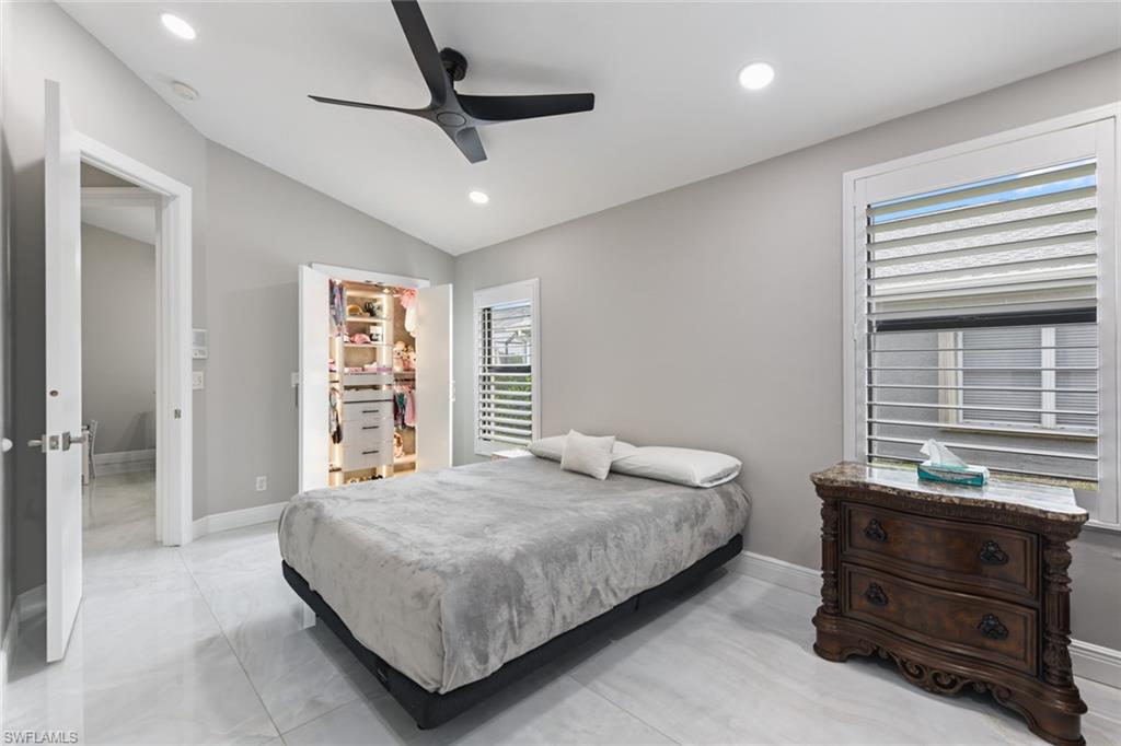 Bedroom with a spacious closet, vaulted ceiling, ceiling fan, and recessed lighting