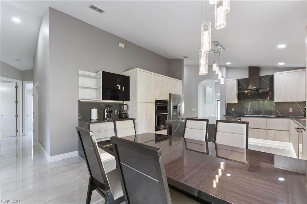 Dining space with recessed lighting and arched walkways