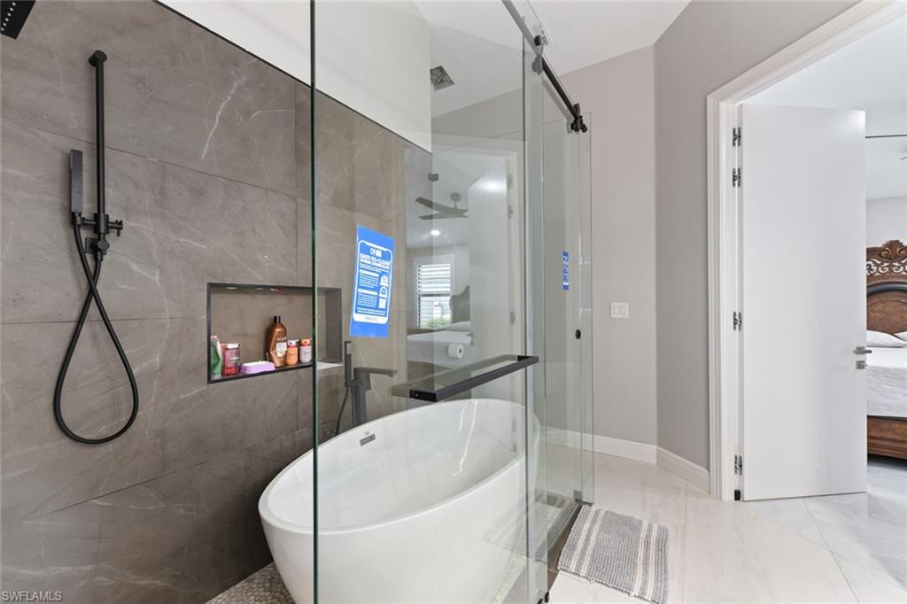 Full bathroom featuring ensuite bathroom, a shower stall, and a freestanding tub
