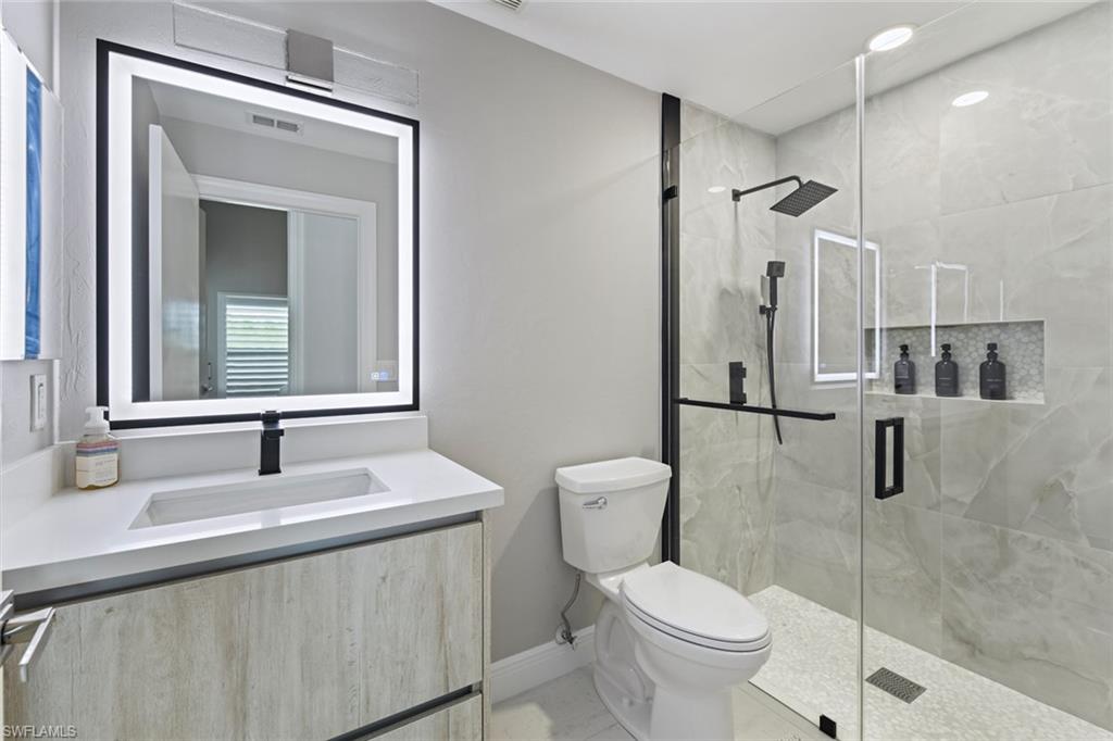 Full bathroom featuring vanity and a marble finish shower
