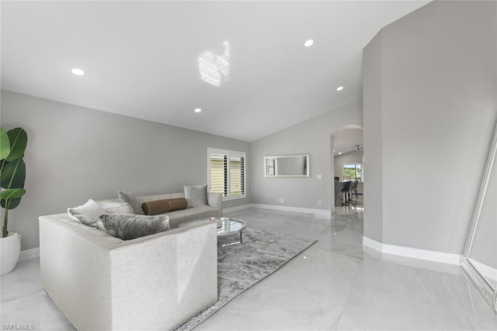 Living area featuring arched walkways, recessed lighting, and vaulted ceiling