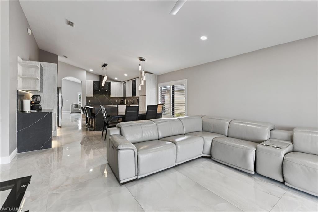 Living room with arched walkways and recessed lighting