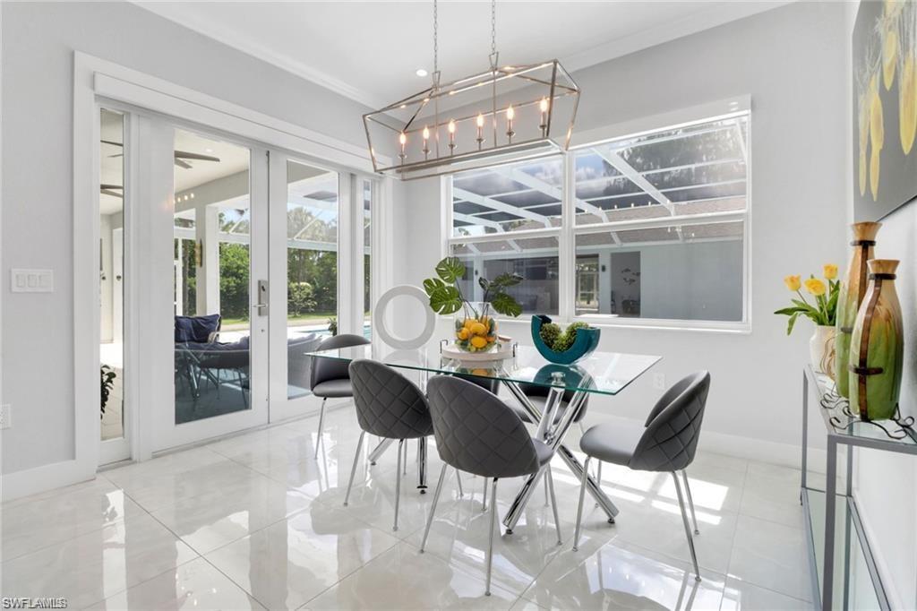 Dining area featuring french doors, suspended lighting, and crown molding