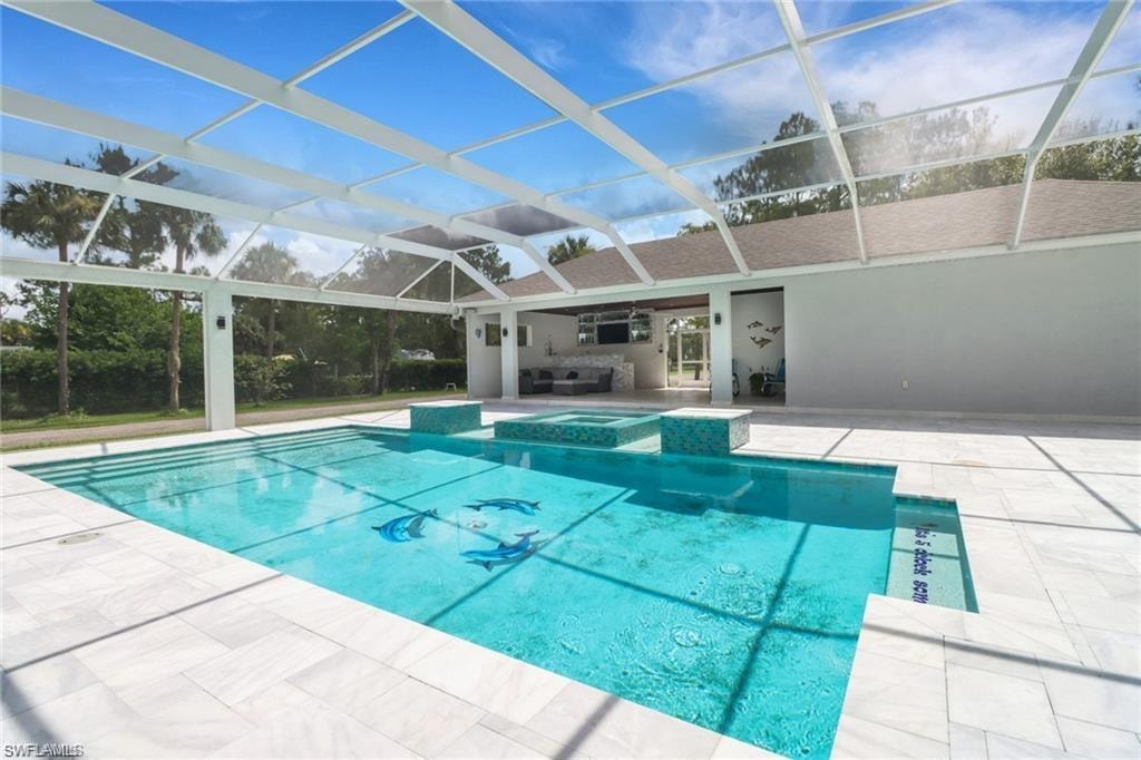 Combined pool / hot tub with a lanai, a patio area, and a sunroom