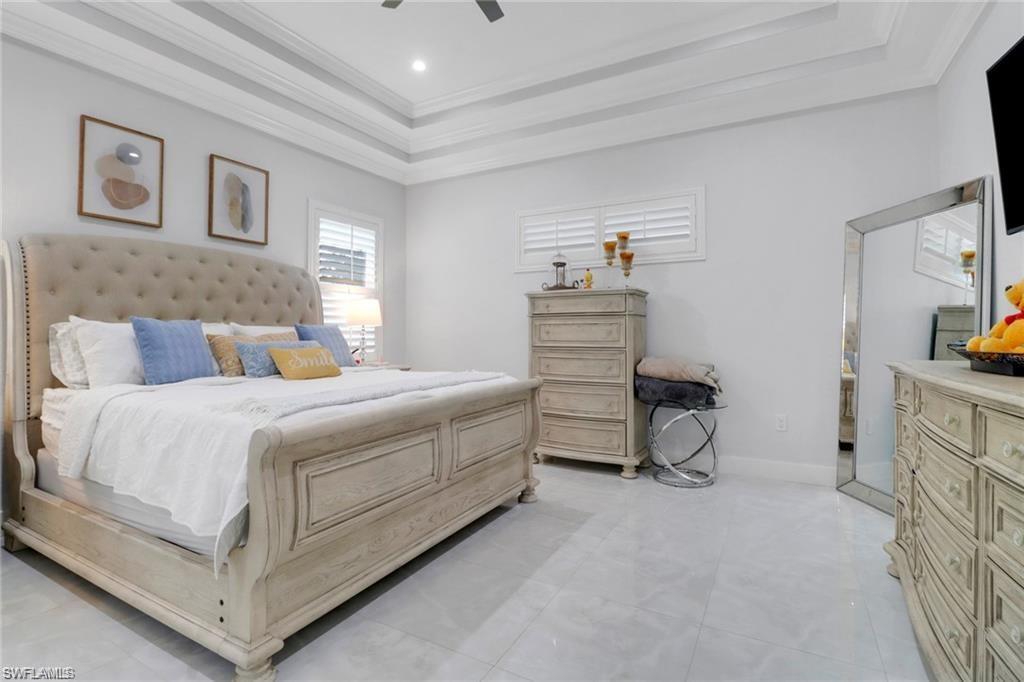 Bedroom featuring a tray ceiling, crown molding, and ceiling fan