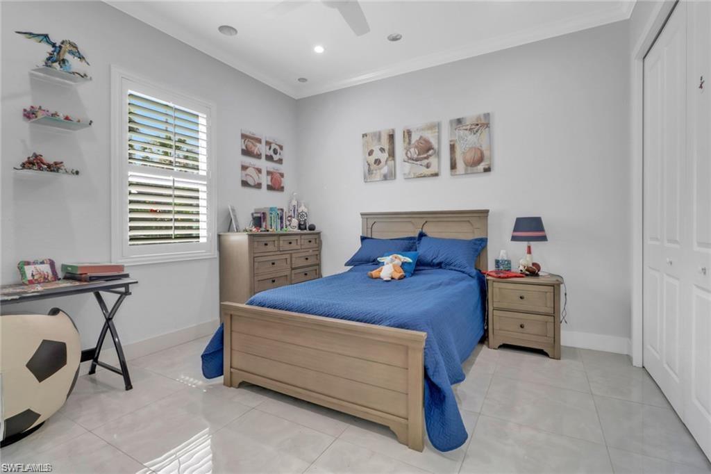 Bedroom with light tile patterned floors, a closet, crown molding, ceiling fan, and recessed lighting