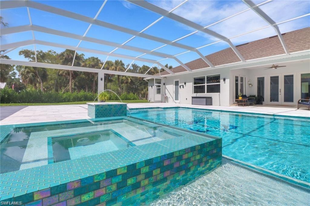 Relaxing pool / spa with a patio area, a lanai, french doors, and a sunroom