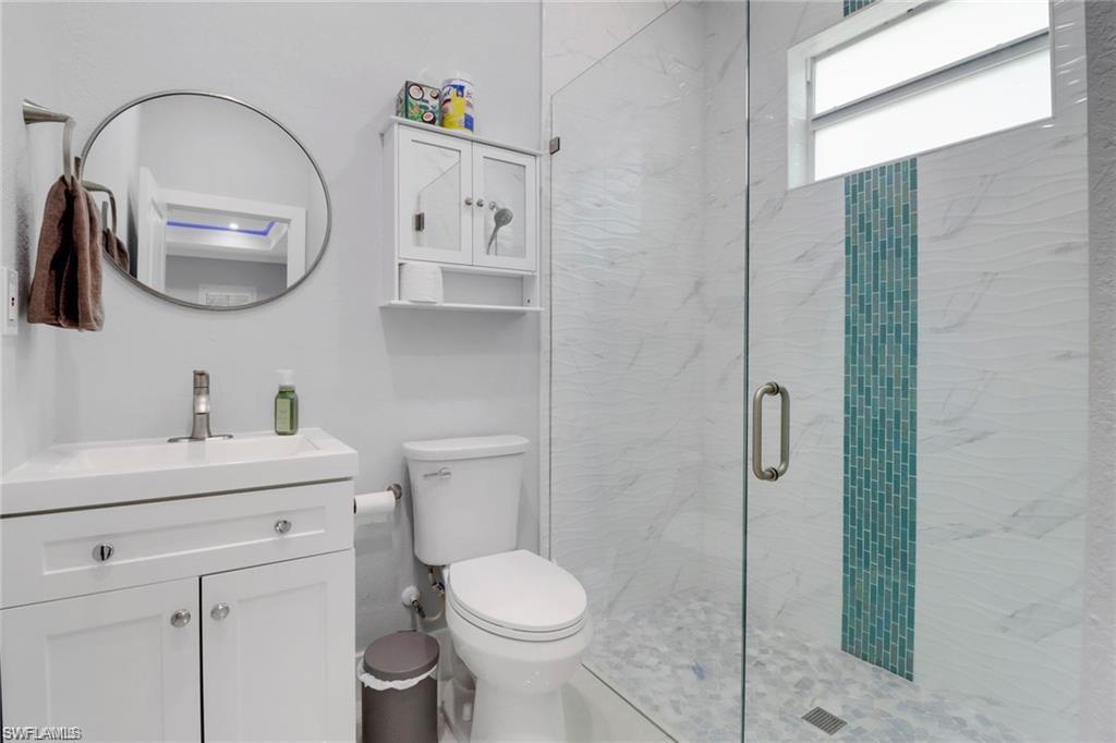 Bathroom with vanity and a marble finish shower