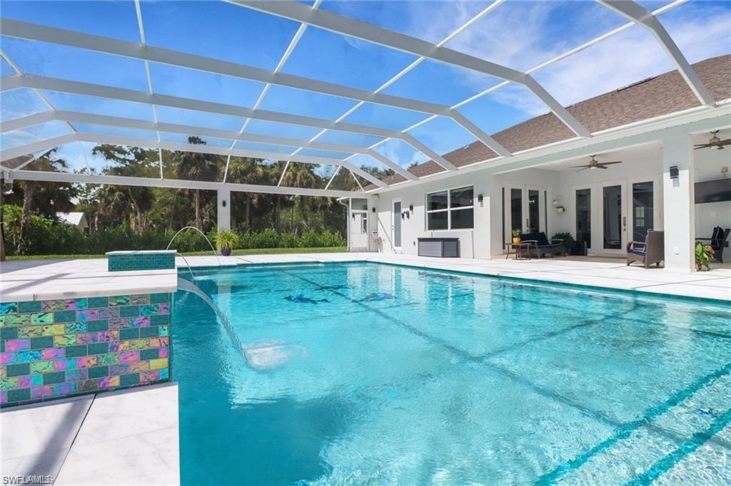 Outdoor pool featuring a patio, glass enclosure, and a sunroom