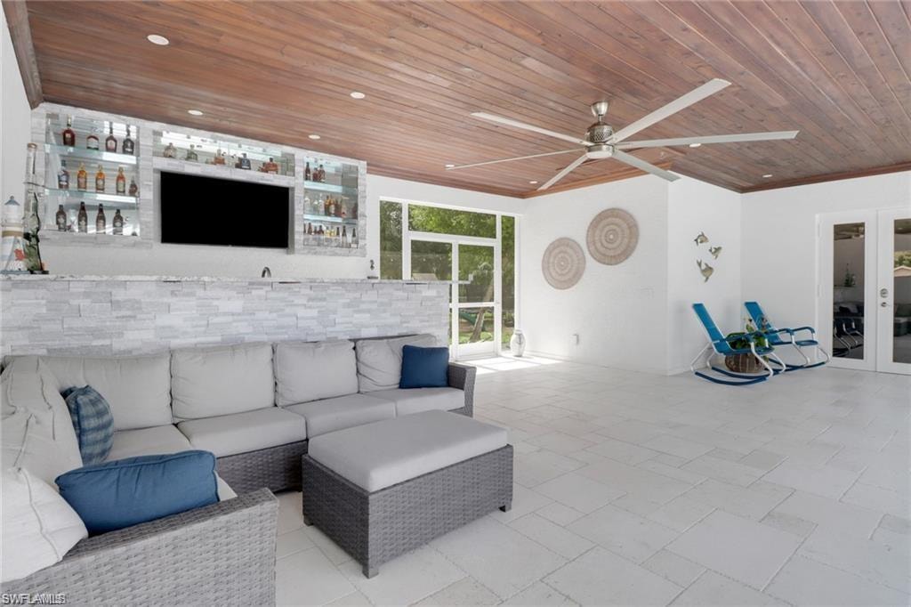 View of patio / terrace with outdoor seating, ceiling fan, and french doors