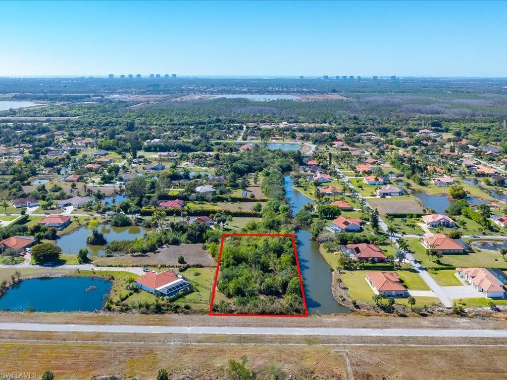 Aerial perspective of suburban area featuring property parcel outlined and a large body of water