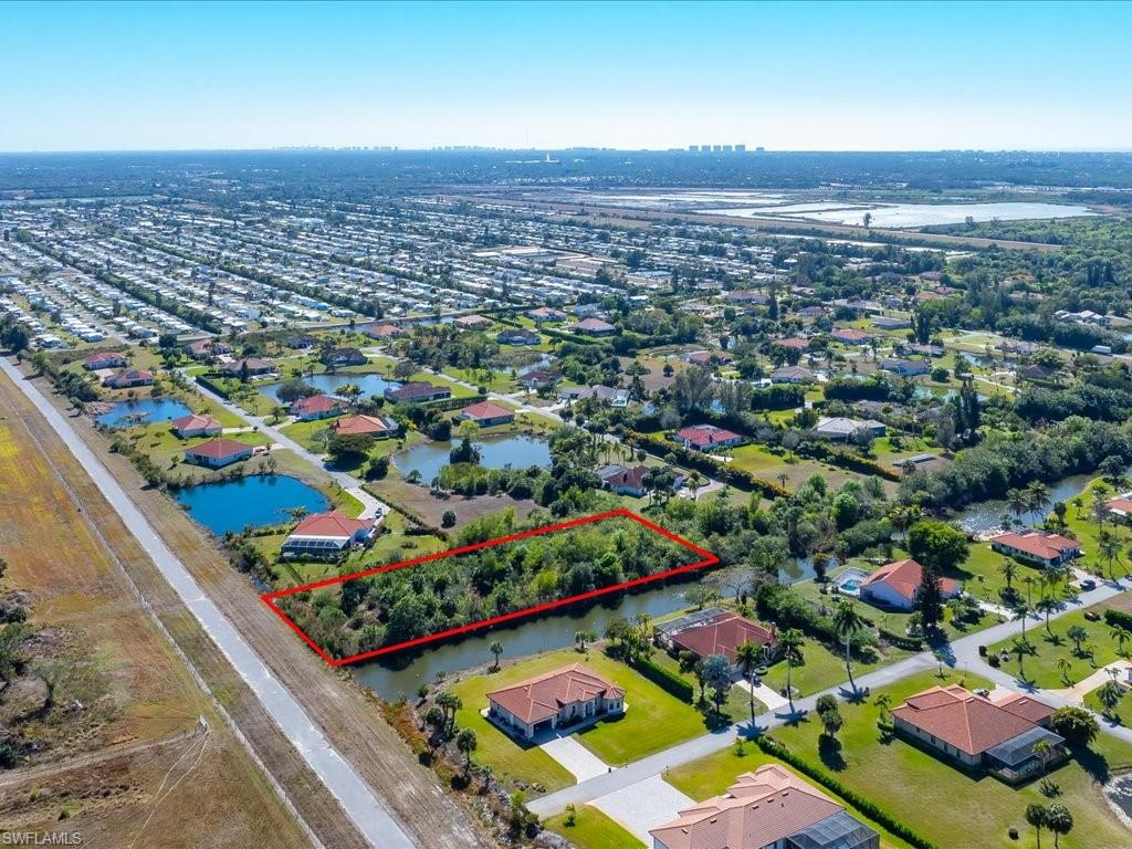 Aerial view of residential area with property parcel outlined and a nearby body of water