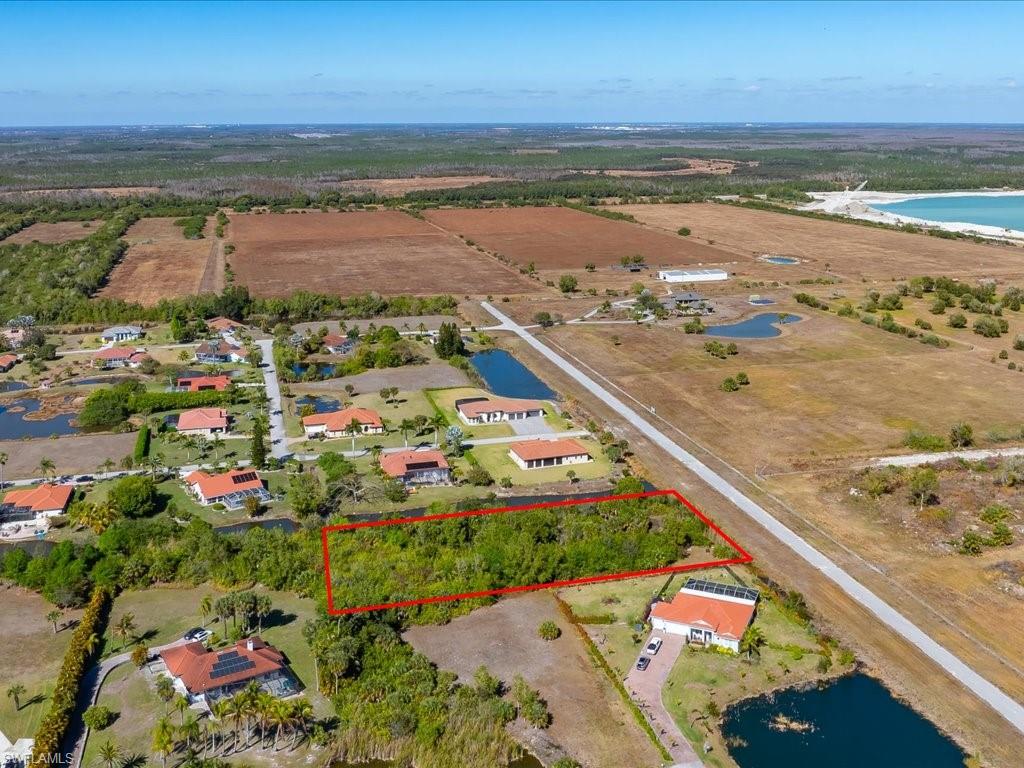 Overview of rural landscape with property parcel outlined and a large body of water