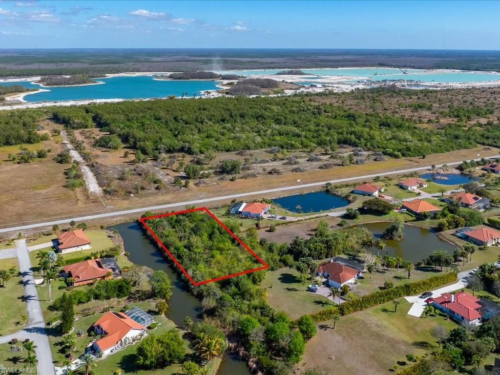 Aerial view of property's location with property parcel outlined and a large body of water