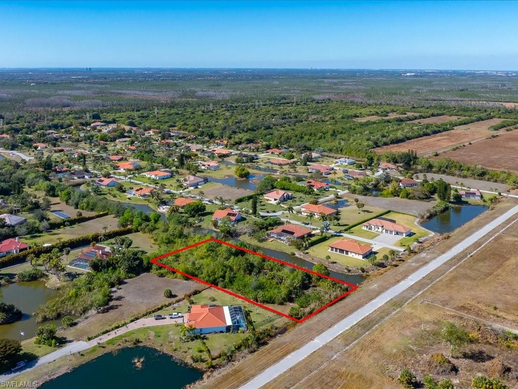 Aerial overview of property's location with property parcel outlined and a nearby body of water
