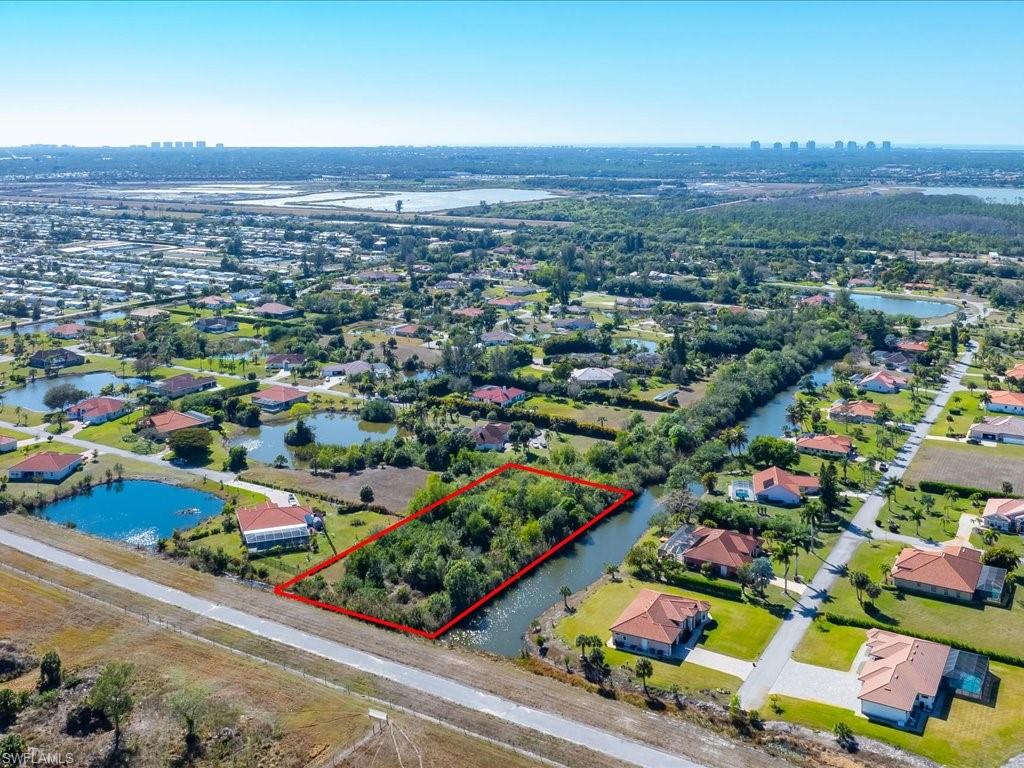 Aerial view of residential area featuring property boundaries highlighted and a large body of water