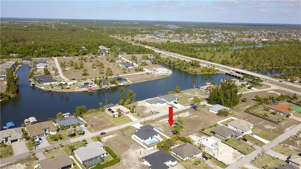 Aerial overview of property's location featuring nearby suburban area and a newaterarby body of