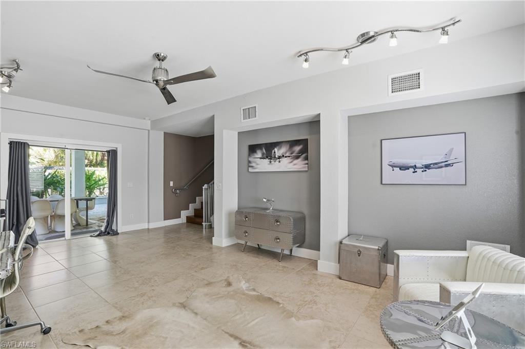 Living area featuring ceiling fan and track lighting