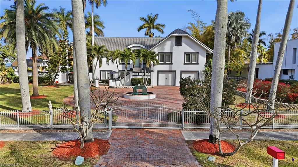 View of front of home featuring a fenced front yard, a gate, stucco siding, an attached garage, and a tile roof