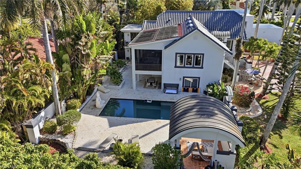 Back of house with a patio, stucco siding, an outdoor pool, and view of wooded area