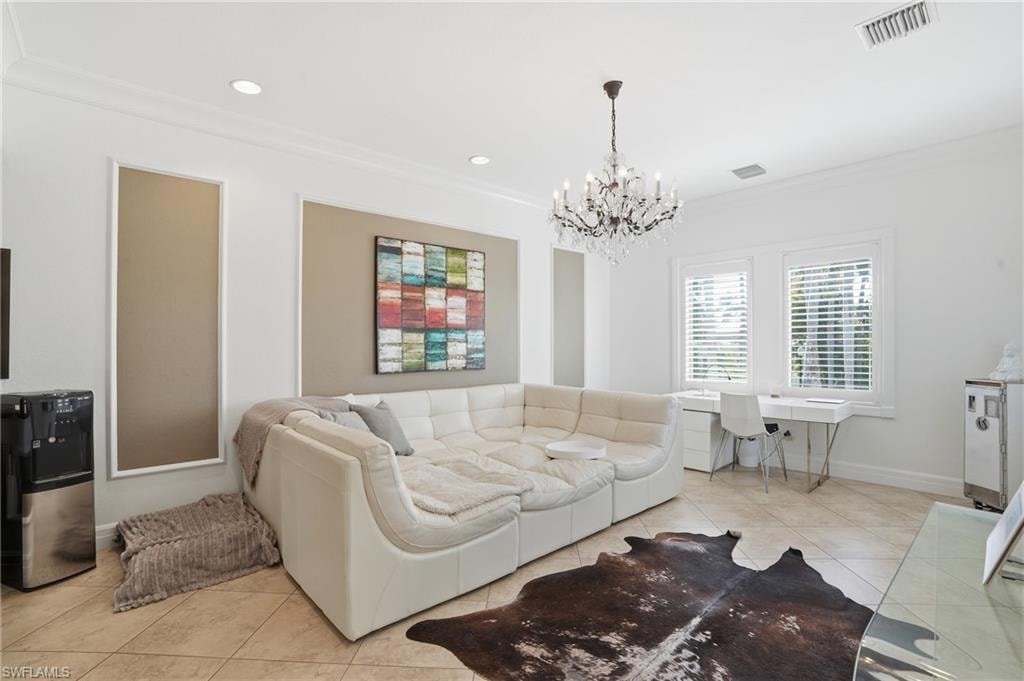 Living area featuring light tile patterned floors, crown molding, and hanging lights