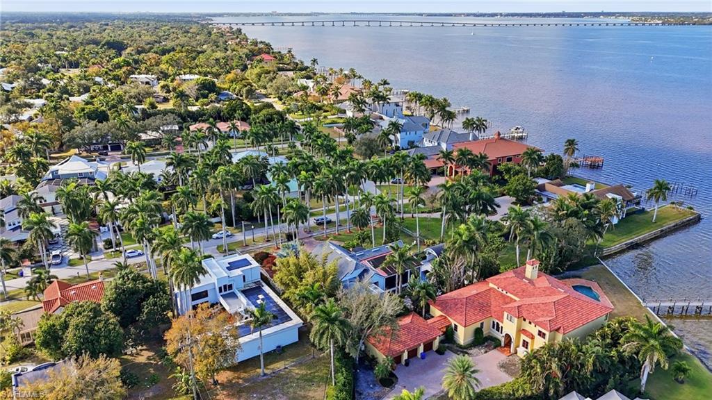 Aerial perspective of suburban area with a nearby body of water and a notable bridge