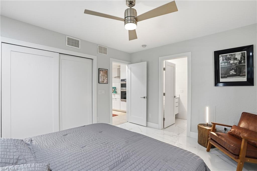 Bedroom featuring a closet, light marble finish floors, and a ceiling fan