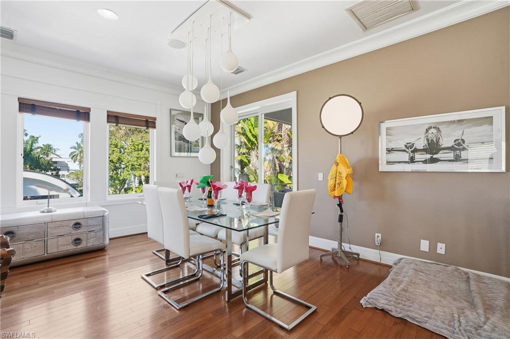 Dining room with wood-type flooring and ornamental molding