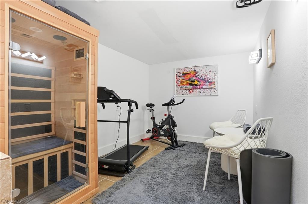 Exercise area with a relaxing sauna and light tile patterned floors