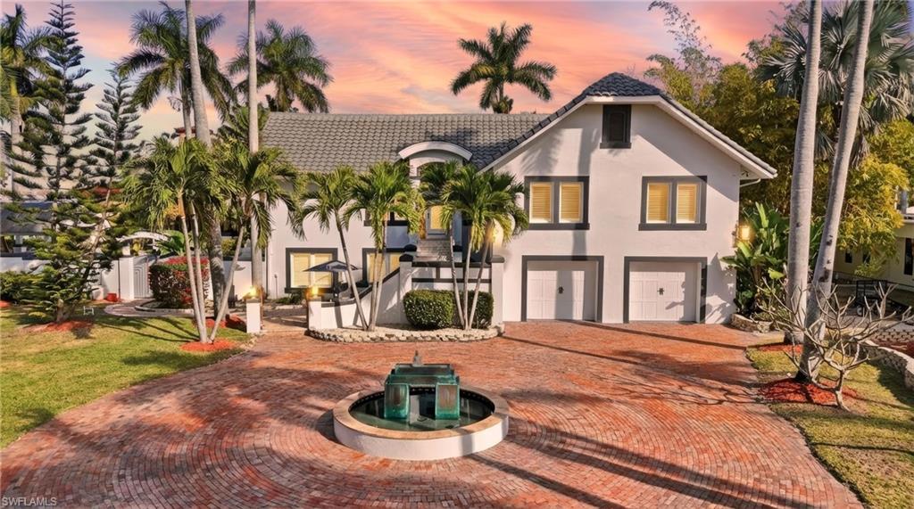 Mediterranean / spanish home with stucco siding, a garage, decorative driveway, and a tiled roof