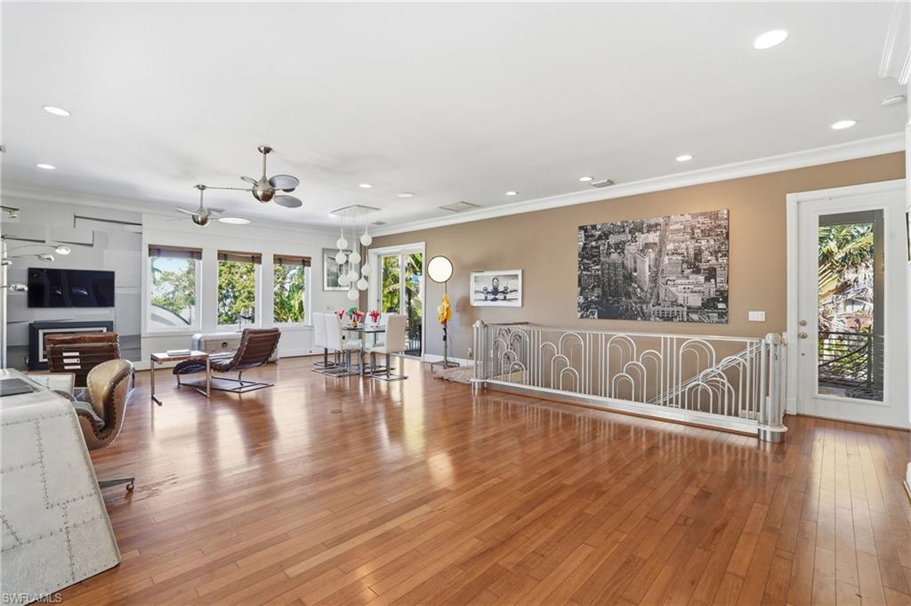 Living room with light wood-style flooring, crown molding, plenty of natural light, recessed lighting, and a ceiling fan