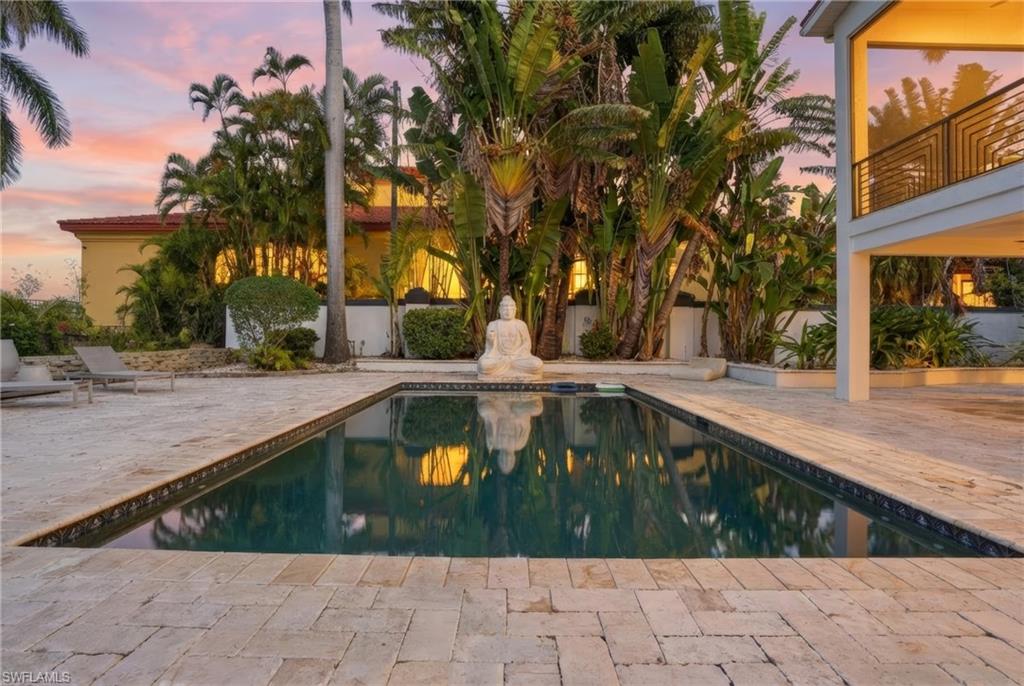 Pool at dusk with an outdoor pool and a patio area