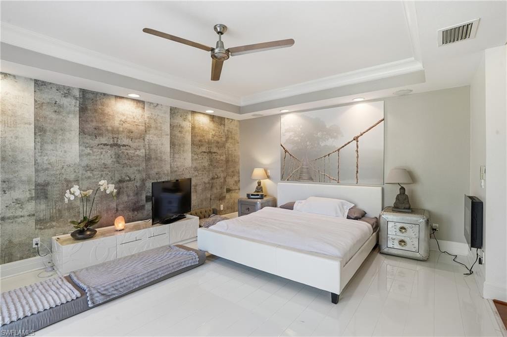 Bedroom with recessed lighting, crown molding, ceiling fan, a raised ceiling, and an accent wall
