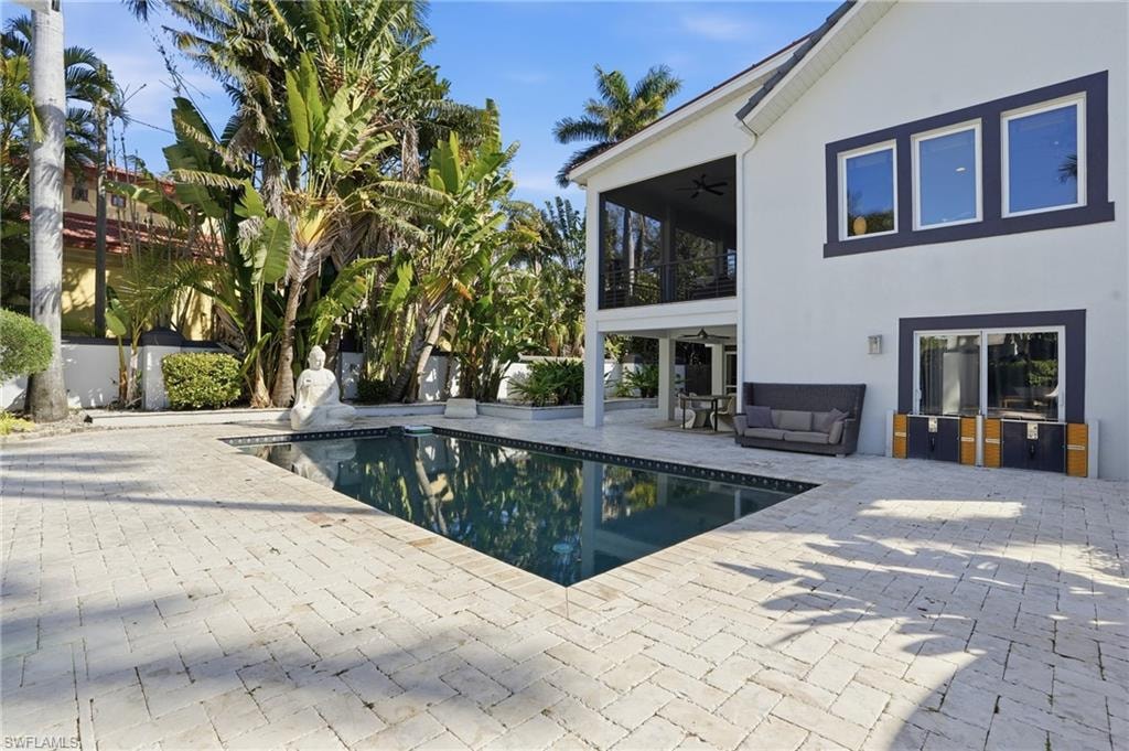 Swimming pool with a patio area, a sunroom, an outdoor lounge area, and a balcony