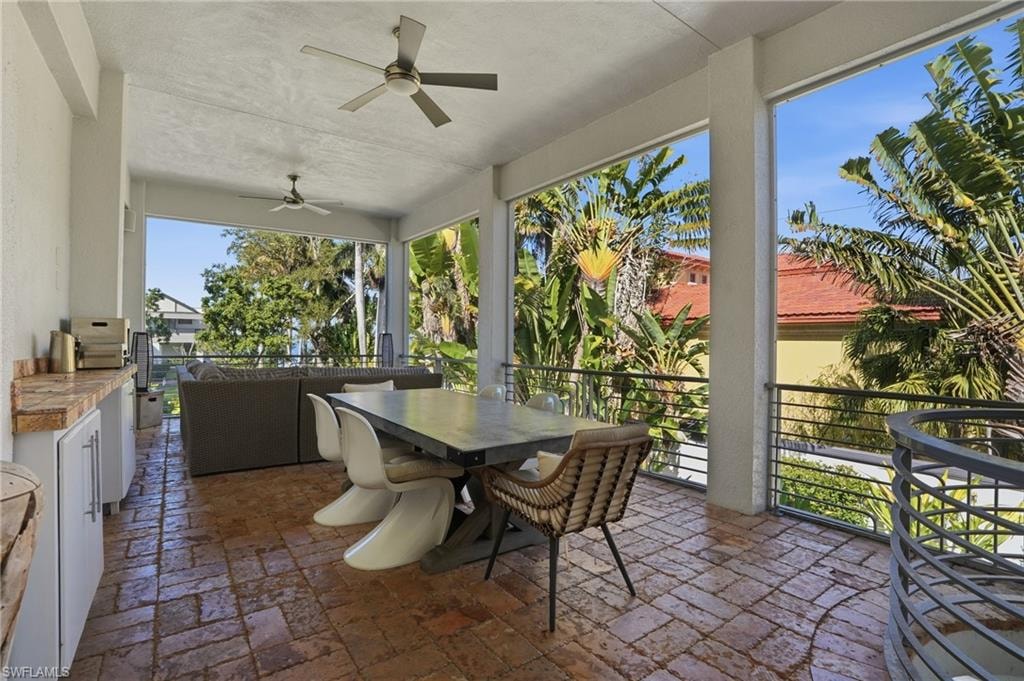 Sunroom featuring a ceiling fan, outdoor dining space, and a patio area