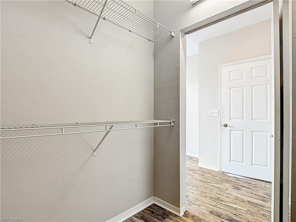 Walk in closet with light wood-style floors