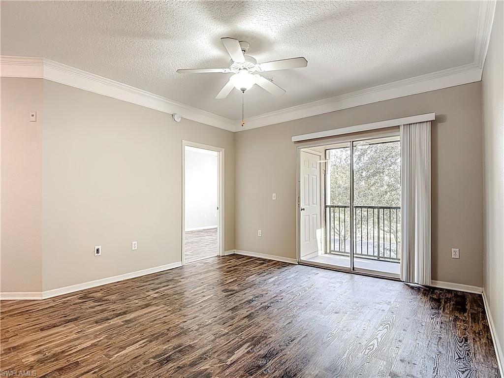 Unfurnished room with dark wood-style flooring, a textured ceiling, ornamental molding, and ceiling fan
