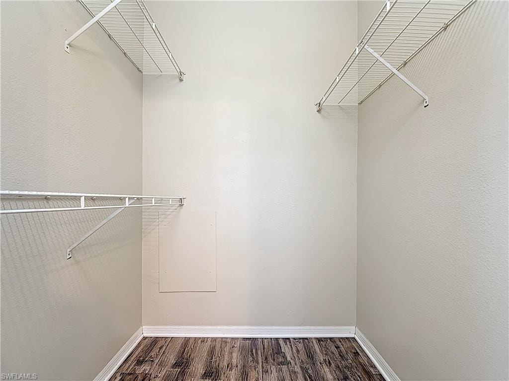 Walk in closet featuring dark wood finished floors