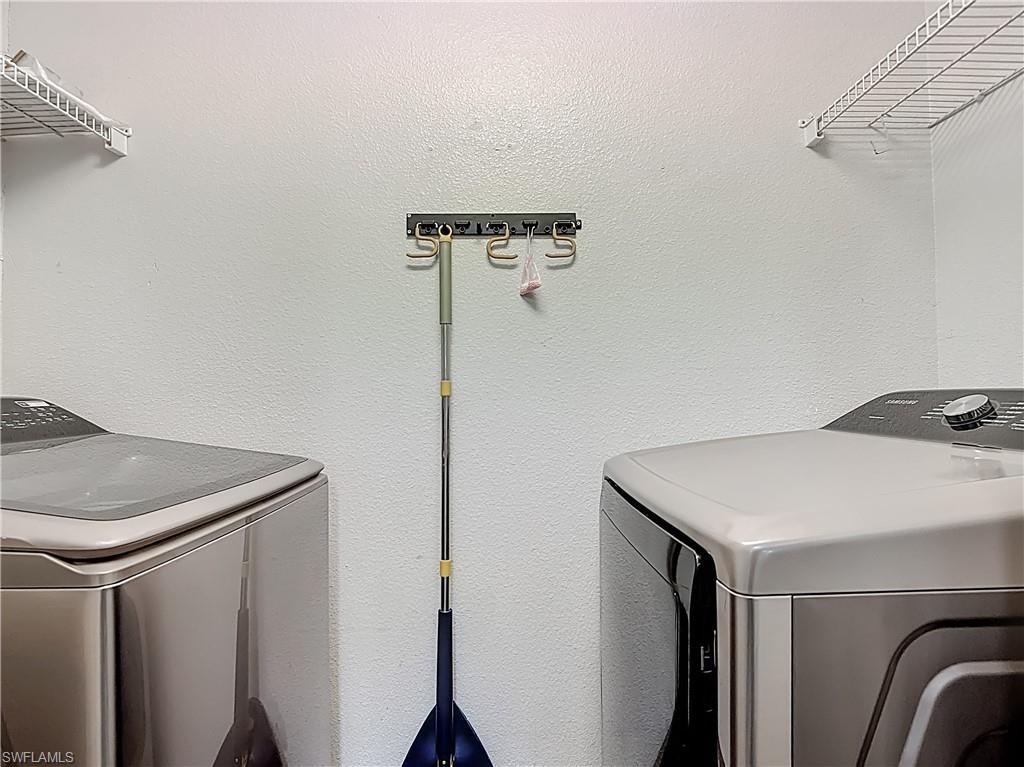 Laundry area featuring washer and clothes dryer and a textured wall