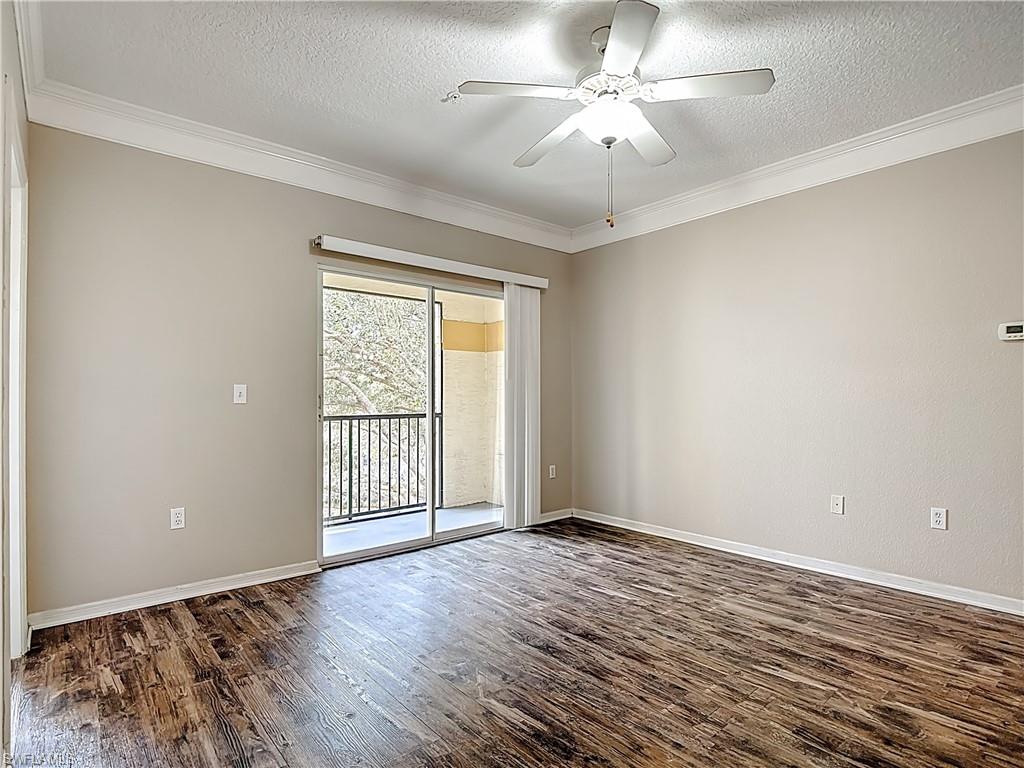 Spare room with a ceiling fan, a textured ceiling, dark wood-style floors, and ornamental molding