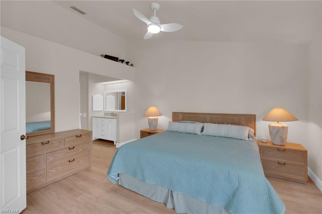 Primary bedroom featuring light wood-style floors, a ceiling fan, and vaulted ceiling