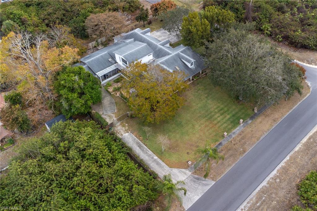 View of subject property with a tree filled landscape