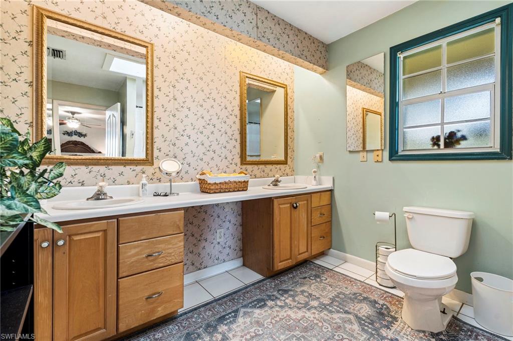 Full bath with double vanity and light tile patterned flooring