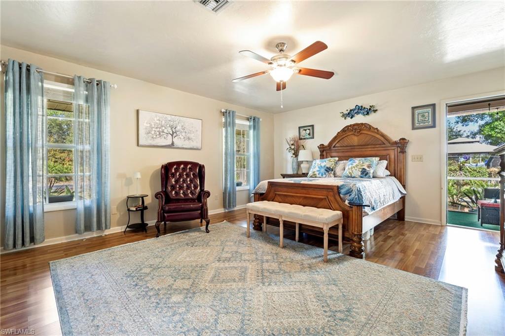 Bedroom featuring access to outside, wood finished floors, and ceiling fan