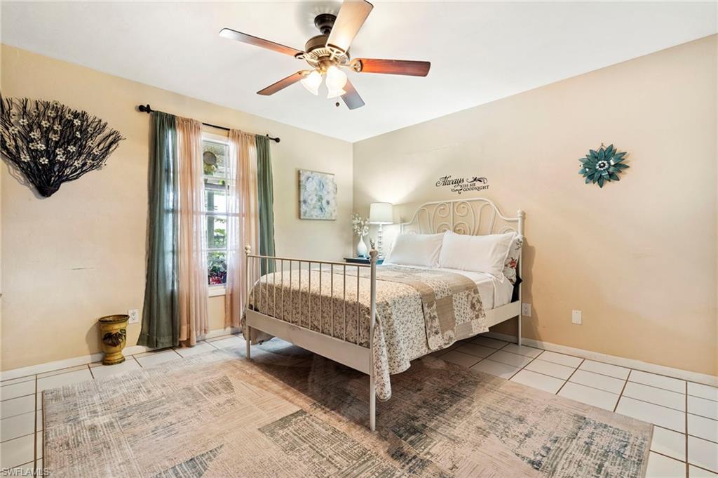 Bedroom with light tile patterned floors and ceiling fan